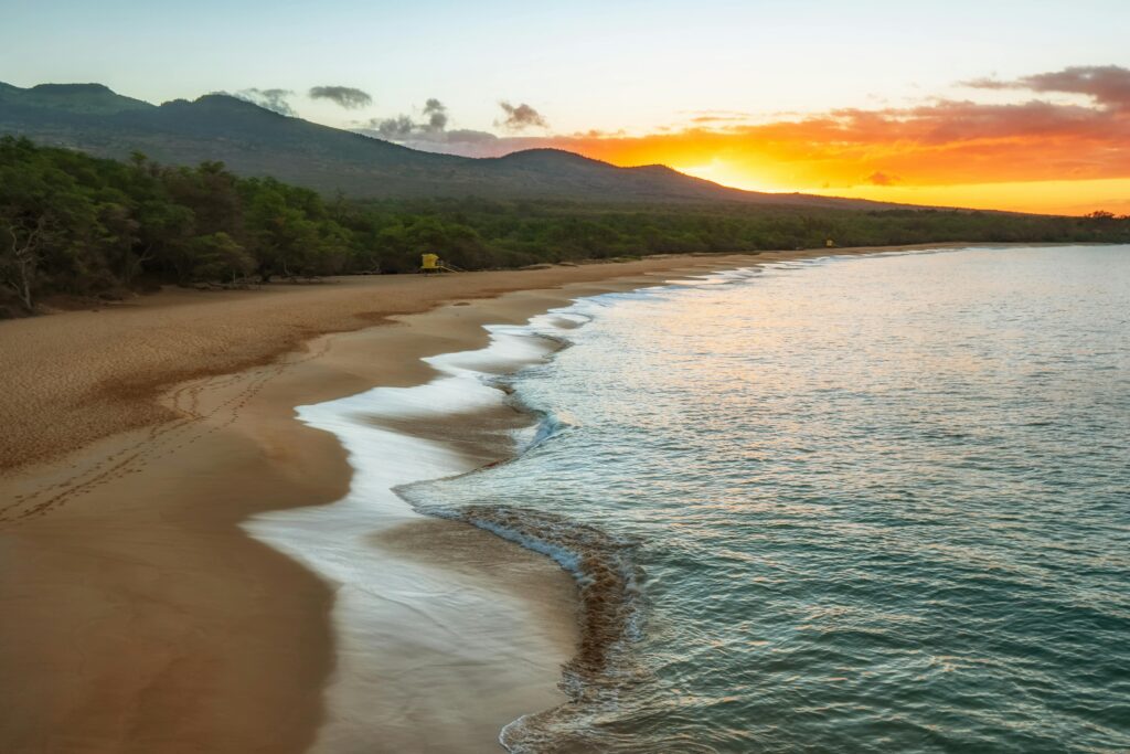 A Hawaiian beach and coast at sunset.